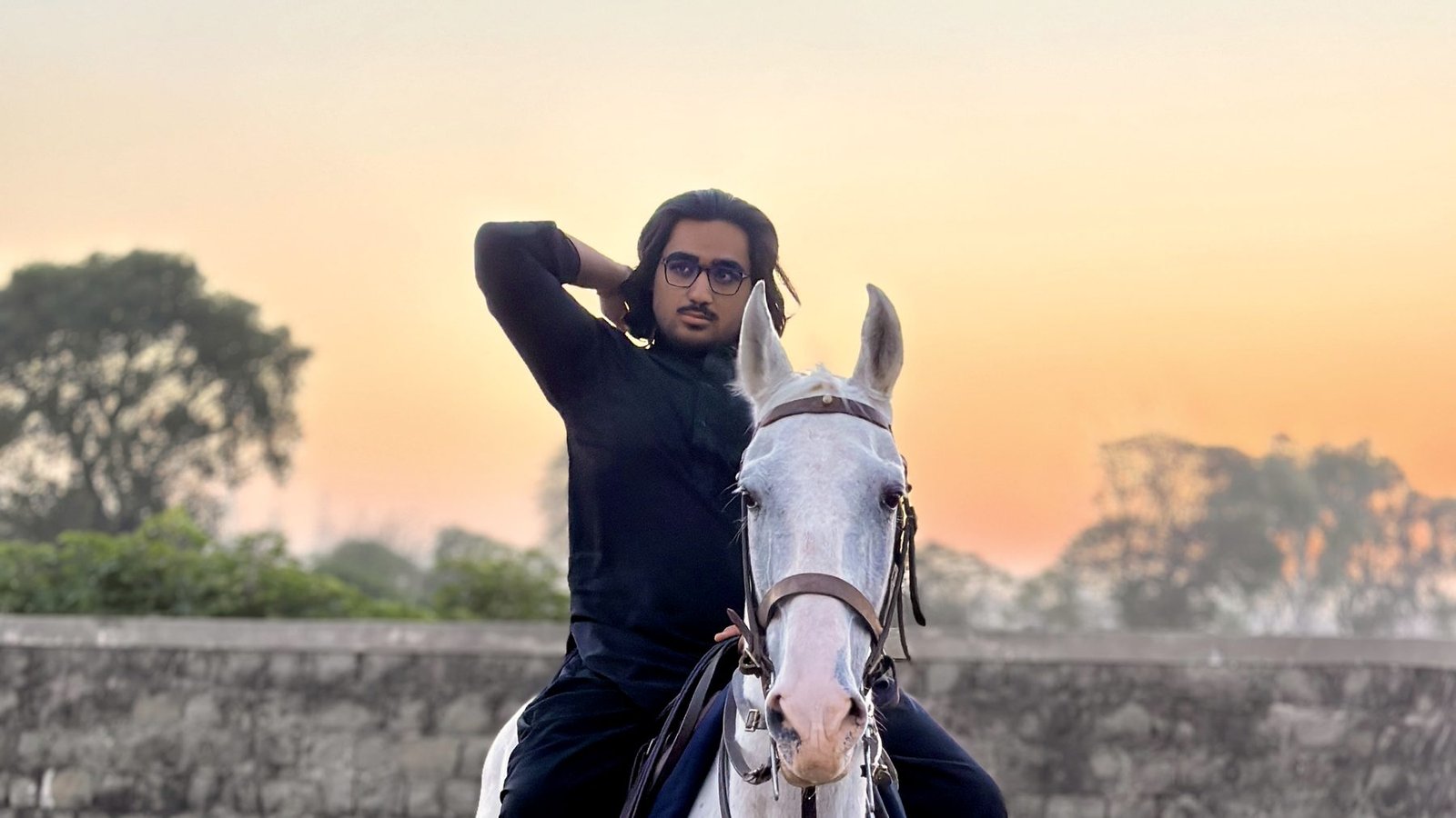 Ali Shayan Haider on horseback at sunset in rural Punjab